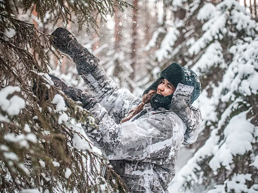 Житель Тюмени весело проводит время в заснеженном лесу.